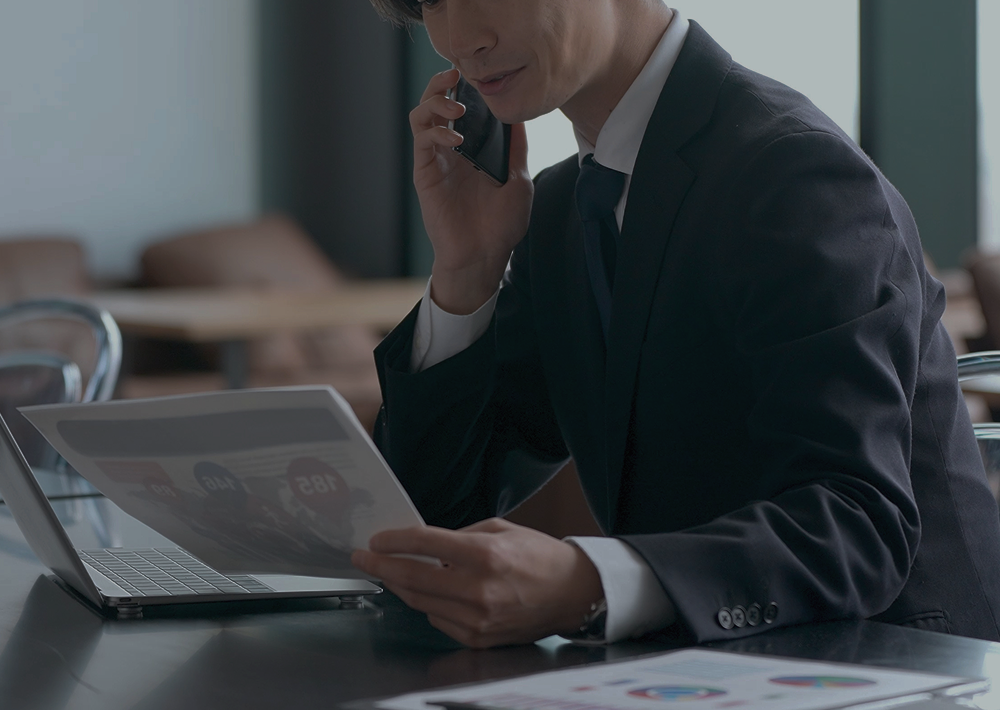 電話をしながら資料を確認するビジネスパーソン